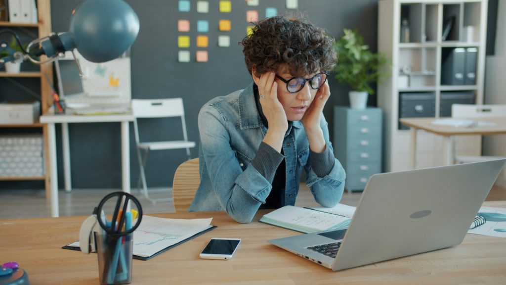 Stressed professional at a laptop in an office